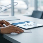 Une personne utilisant une tablette pour confirmer une demande d'indemnisation de vol dans un aéroport.