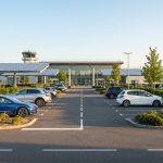 Voitures garées sous des ombrières photovoltaïques devant le terminal de l'aéroport de Beauvais.
